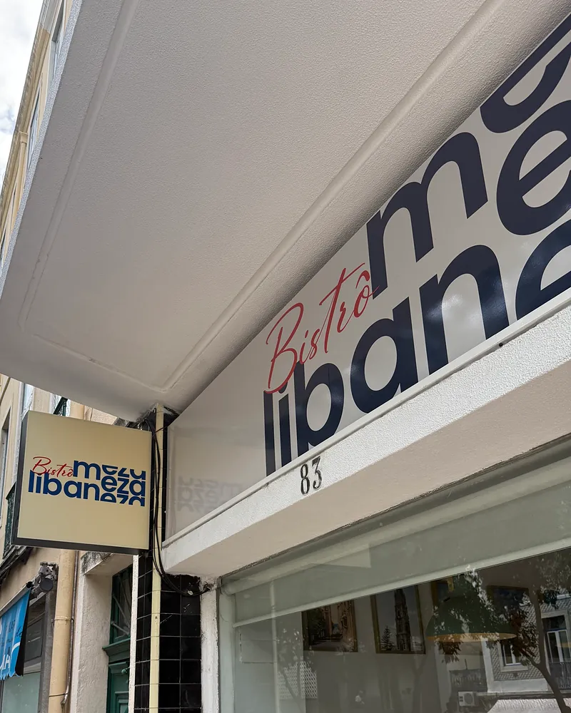 O letreiro Bistrô meza libaneza por cima da montra, com o número 83, e a placa de bandeira na fachada